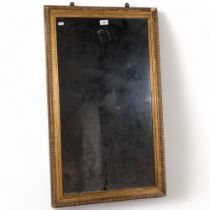 A 19th century gilt-gesso framed rectangular wall mirror, 90cm x 54cm overall, with label for