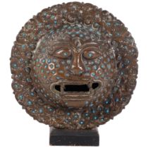 A South East Asian engraved and repousse metal mask, with inset turquoise bosses, diameter 21cm Good