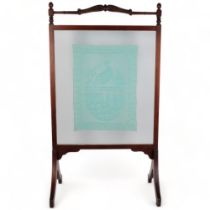 An Edwardian mahogany framed fire screen, the central glass panel containing a needlework panel