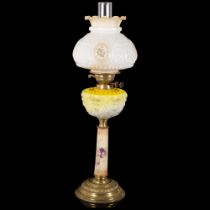 An Antique brass and glass oil lamp, with a white embossed and painted shade with yellow glass and