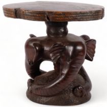 A carved hardwood stool, supported by 3 carved elephant heads, 35cm