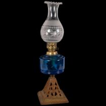 A Victorian glass and gilt-metal oil lamp, with etched shade and frilled edge, blue glass font on