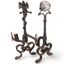 A pair of Victorian Arts and Crafts scrolled wrought-iron andirons, 1 mounted with an elephant's