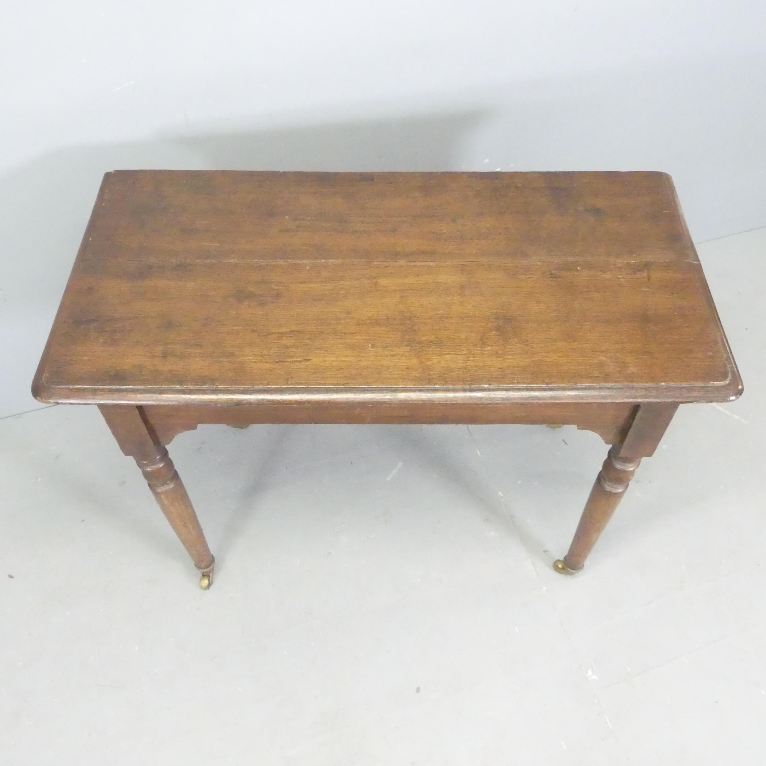 A Victorian oak hall table, with turned legs and brass casters. 100x77x48cm. - Image 2 of 2