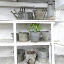 A group of twelve galvanised items to include watering cans, buckets, etc.