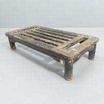 An antique elm Chinese footstool. 69x17x36cm. Originally black lacquered, and some remains on legs