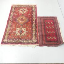 A red-ground Persian rug, 155x92cm, and a Tekki mat, 99x63cm. (2)