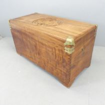 A large Chinese camphorwood chest, with carved top, brass mounts and tray fitted interior.