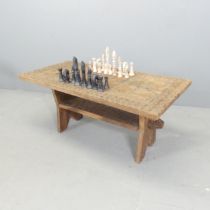A hardwood two-tier games top coffee table, with a set of hardstone chess pieces. 96x42x46cm.