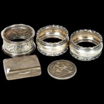 A Victorian 1889 silver crown, 3 various silver napkin rings, and a small silver box engraved The