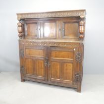 An antique oak Jacobean style two-section court cupboard, with chip-carved decoration and raised