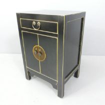 A Chinese black lacquered cabinet of small size, with single drawer above two doors. 40x61x32cm.