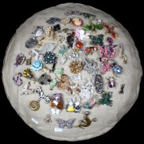 A colourful display of approximately 50 brooches, mounted on a domed cushion, examples to include