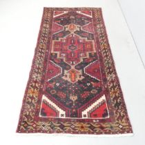 A red-ground Caucasian rug, 205x96cm.