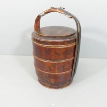 An Oriental red-lacquered four-tier food carrier. Height 71cm.