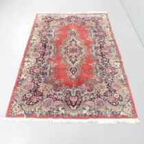 A red-ground Persian rug. 186x125cm.