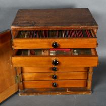 An Antique stained pine collectors cabinet, the seven fitted drawers containing various slides,