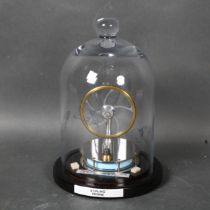 A Stirling engine, mounted under glass dome on stand, height 24cm overall.