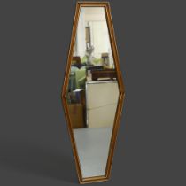 A coffin shaped wall mirror, stained beech framed with brass effect beading, height 111cm.