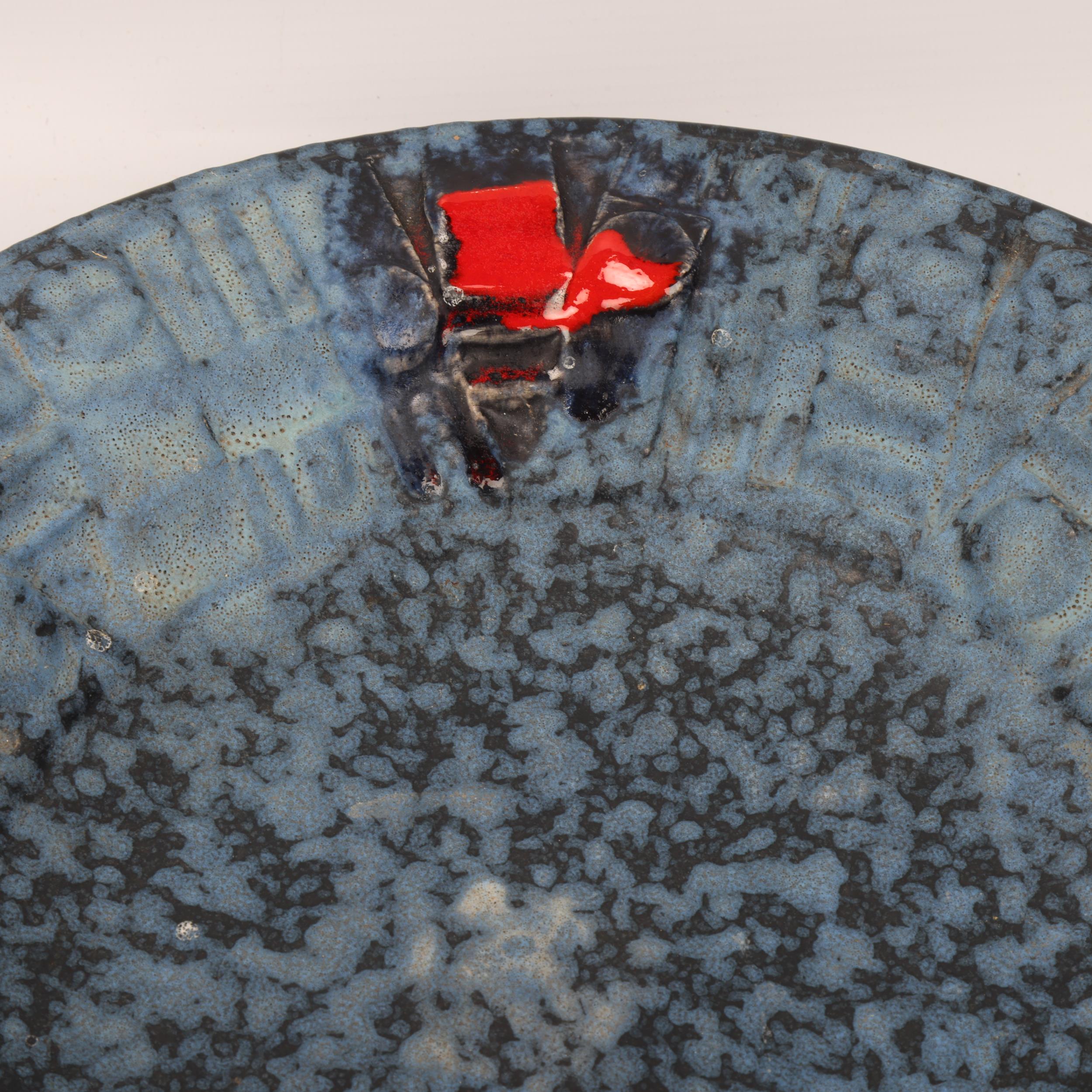 A mid century Brutalist wall hanging plate, with matt blue glaze and red accents, unsigned, diameter - Image 2 of 3