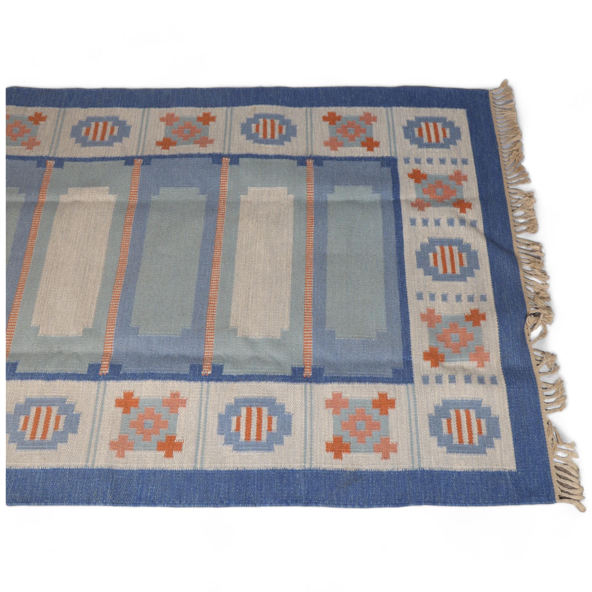A Swedish flatweave rug, with a geometric pattern in shades of blue and dark pink, 205 X 140cms