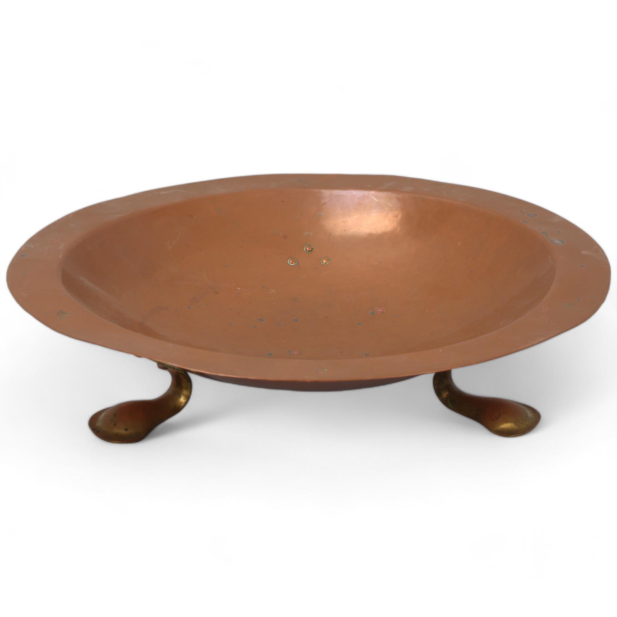 An early 20th century planished copper fruit bowl by the Birmingham Guild Ltd with riveted brass