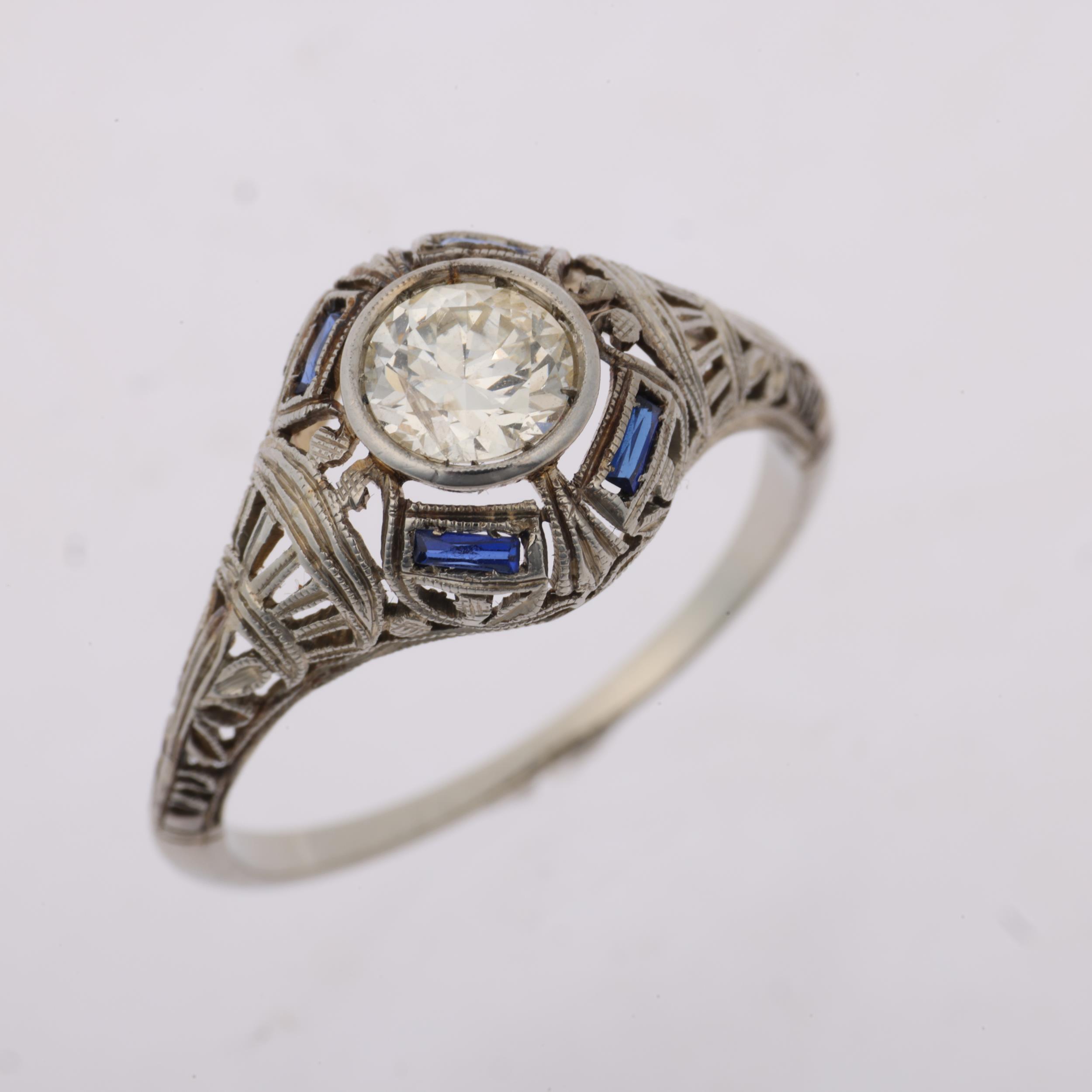 An Art Deco 0.55ct solitaire diamond ring, circa 1930, openwork scroll decoration with rectangular- - Image 2 of 4