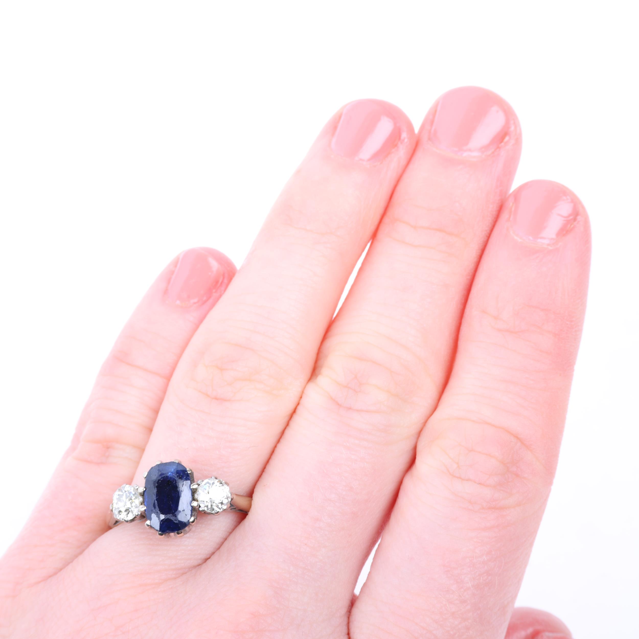 An 18ct white gold three stone sapphire and diamond ring, claw set with 1.7ct oval mixed-cut - Image 4 of 4