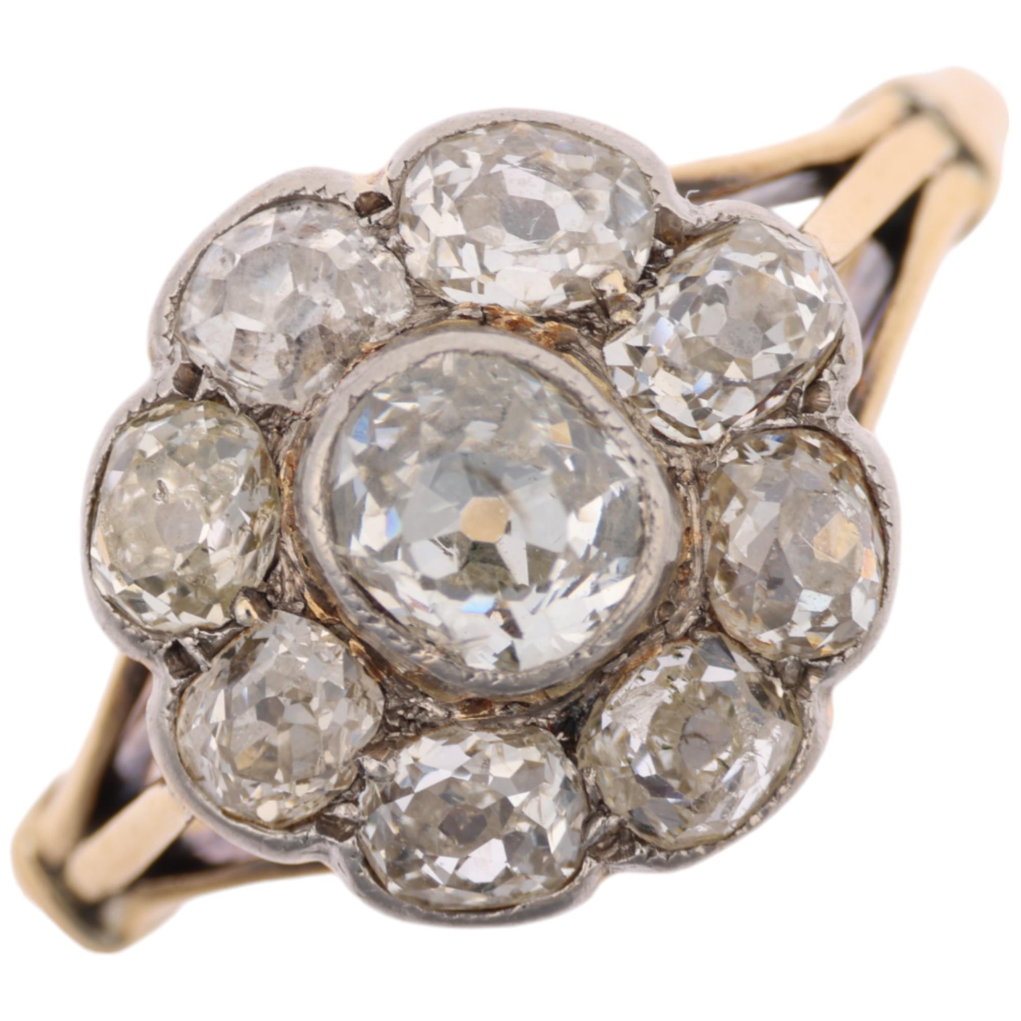 An 18ct gold diamond flowerhead cluster ring, rub-over set with old-cut diamonds, total diamond