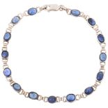 A modern sterling silver sapphire tennis line bracelet, set with oval cabochon sapphires, 20.5cm,