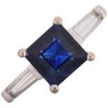 A modern 18ct white gold three stone sapphire and diamond ring, claw set with 1ct square step-cut