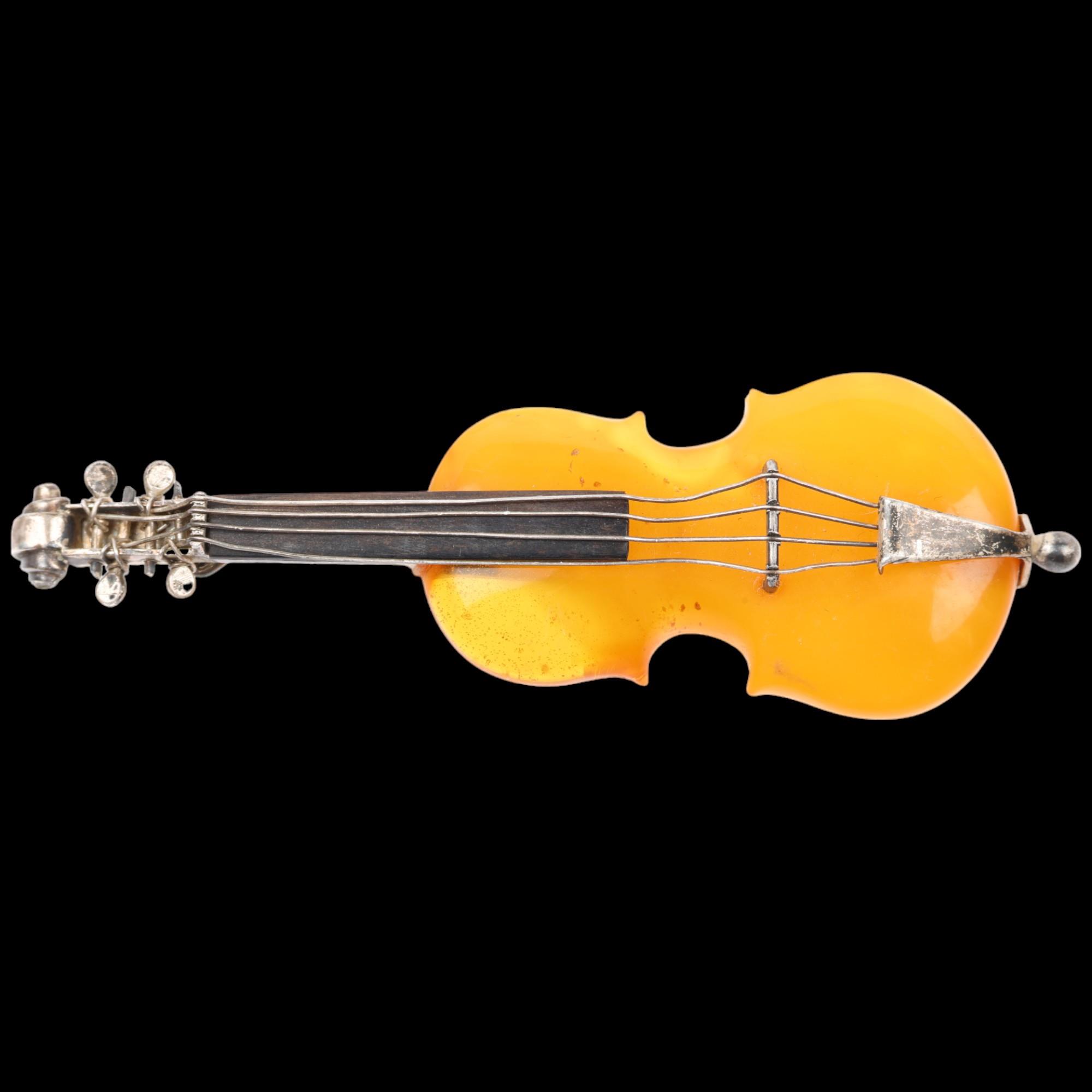 An Antique novelty amber violin brooch, with unmarked silver settings, 75.5mm, 10g Condition Report: