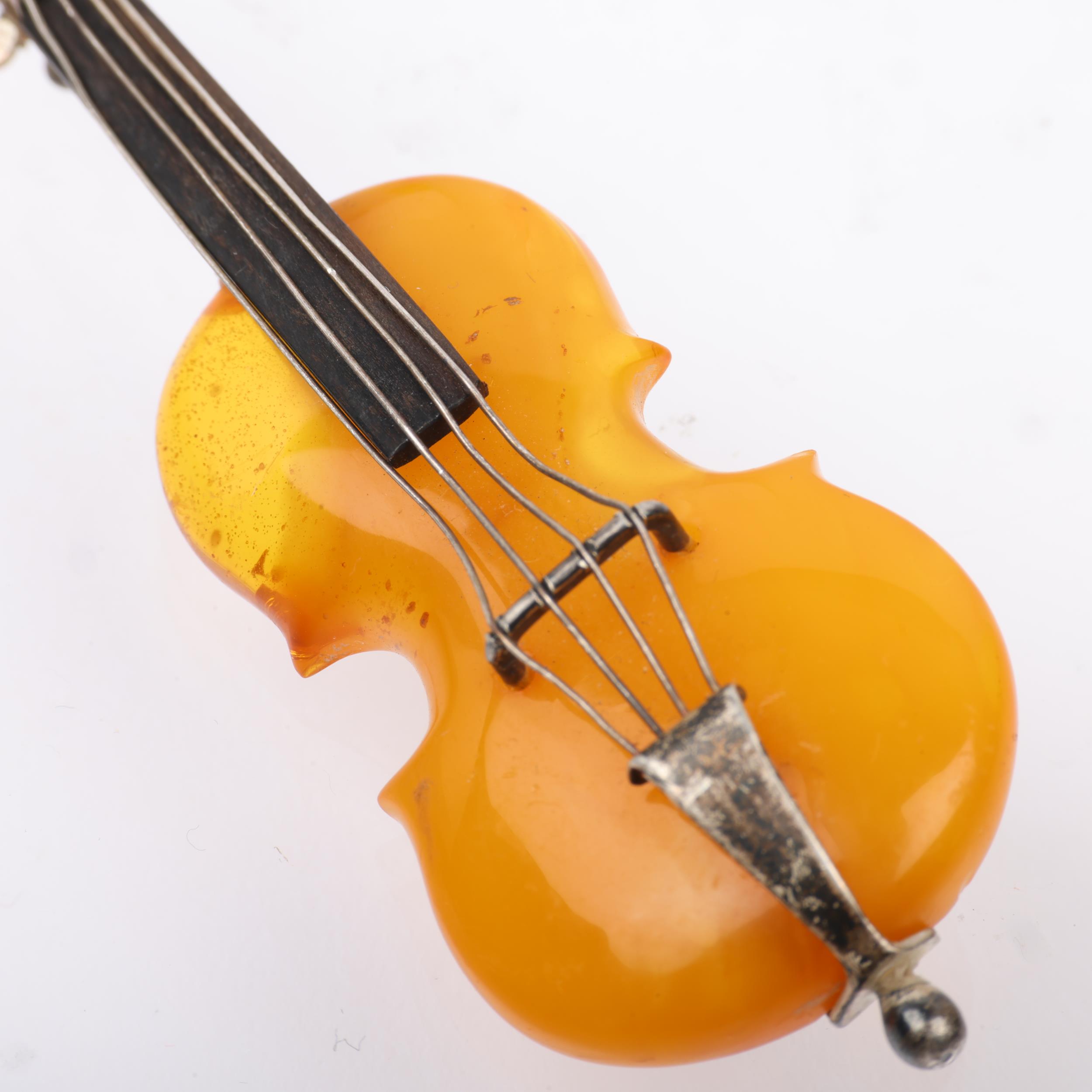 An Antique novelty amber violin brooch, with unmarked silver settings, 75.5mm, 10g Condition Report: - Image 2 of 3