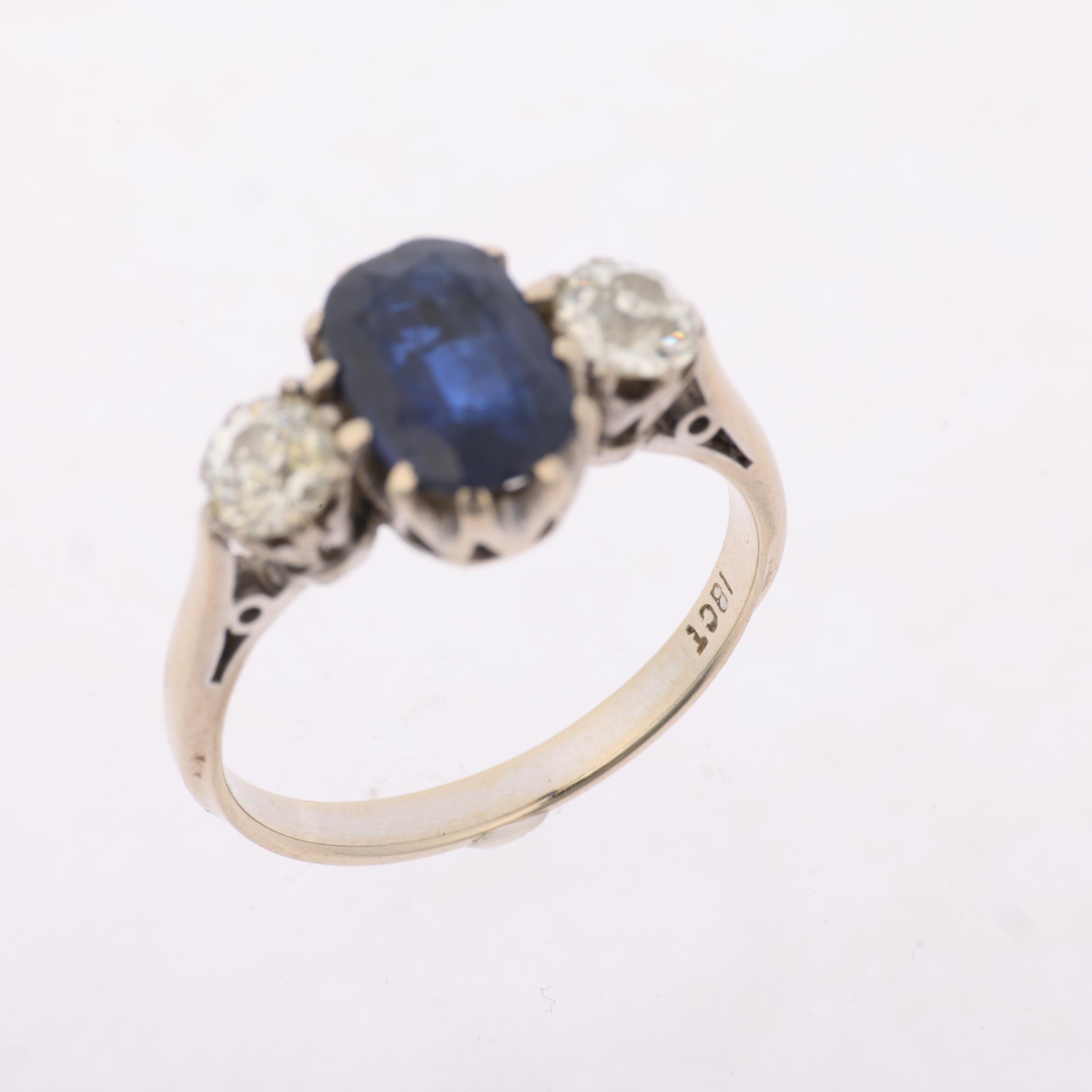 An 18ct white gold three stone sapphire and diamond ring, claw set with 1.7ct oval mixed-cut - Image 3 of 4