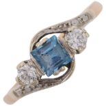An Art Deco 9ct gold three stone blue topaz and diamond crossover ring, platinum-topped set with