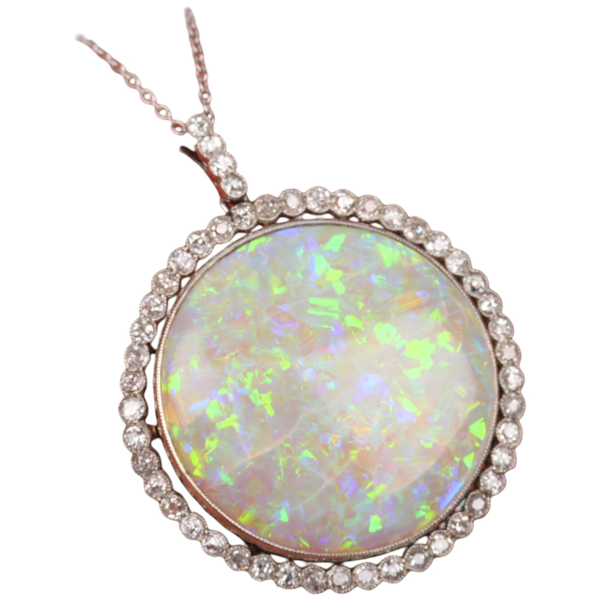 A Belle Epoque opal and diamond cluster pendant necklace, rub-over set with 15ct round cabochon opal
