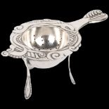 An Art Nouveau Danish silver tea strainer and stand, circa 1917 and 1920, strainer 13cm, stand