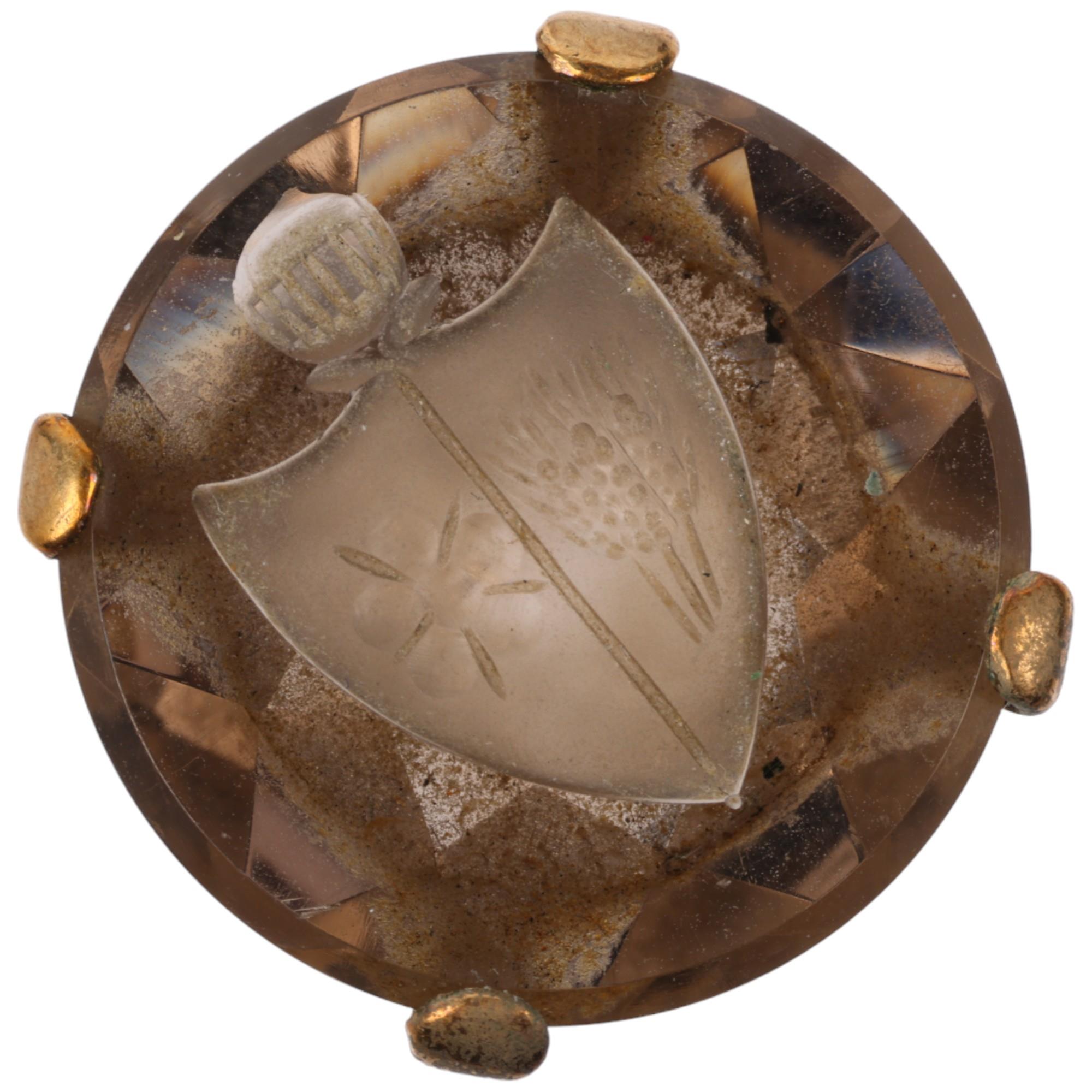 A late 20th century 9ct gold smoky quartz armorial seal ring, the round smoky quartz intaglio carved