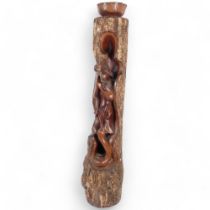 A carved Thai hardwood sculpture, depicting a praying figure with a snake wrapped around her legs,