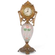 Ornate Antique brass clock, on painted glass stand with floral design, by Gilbert Clock Company,