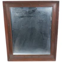 An Arts and Crafts stained wood-framed rectangular wall mirror, with applied decoration, 60cm x