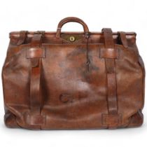A large Antique leather Gladstone travel bag, with hinged folding sides and leather straps, by