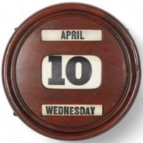 An early 20th century stained wood circular perpetual wall calendar, diameter 30.5cm The frame has