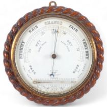 A late 19th/early 20th century cased circular aneroid barometer, carved rope twist decoration,