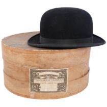 A black bowler hat, by Dunn & Co, with cardboard hat box