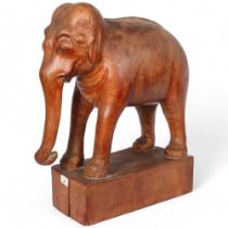 A large carved African study of an elephant on stand, H54cm