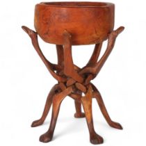 A hand crafted African wood bowl table with collapsible base, base depicts 5 camel style hoofed