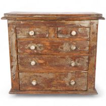 A 19th century distressed pine table-top apprentice piece chest with 2 short and 3 long drawers,
