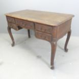 A French oak centre-standing kneehole writing table, with five drawers, cabriole legs and dummy