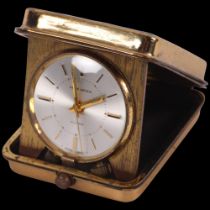 SWISS HOME WATCHES - a Swiss gilt-metal cased travelling alarm clock in folding case, working order,